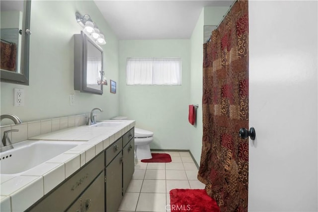 bathroom featuring a sink, tile patterned flooring, toilet, and double vanity