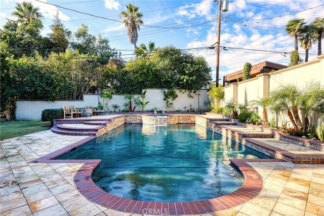 view of pool with a pool with connected hot tub, a patio, and a fenced backyard
