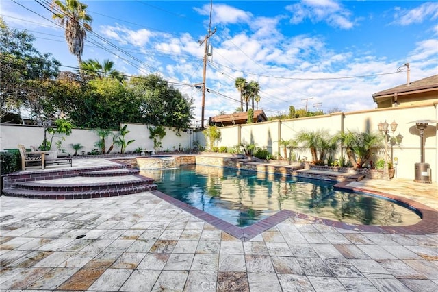 view of swimming pool with a pool with connected hot tub, a patio, and a fenced backyard