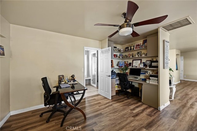 office with a ceiling fan, visible vents, baseboards, and dark wood-type flooring