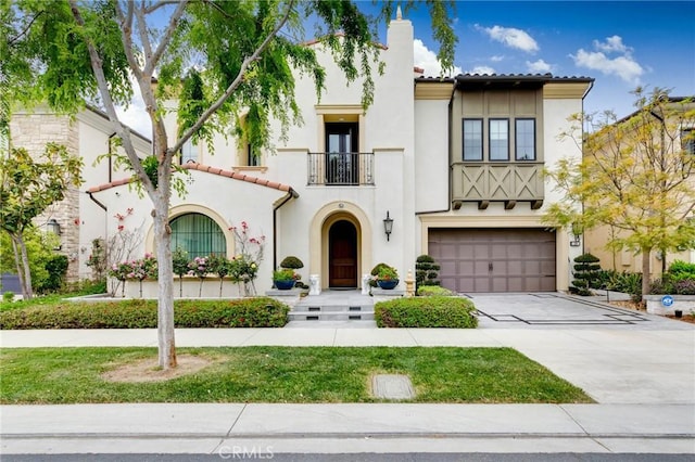114 Interstellar, Irvine, CA 92618 - mediterranean / spanish-style house featuring a tile roof, a garage, a balcony, driveway, and stucco siding