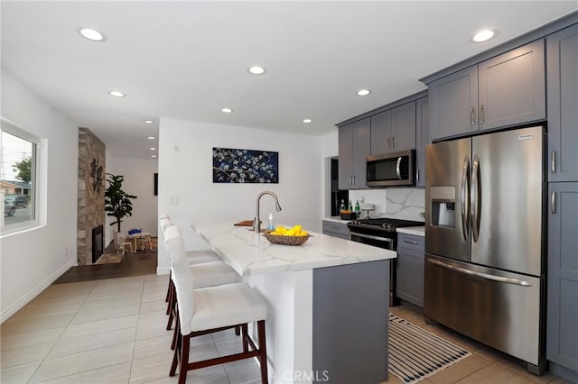 kitchen with recessed lighting, light stone countertops, and stainless steel appliances