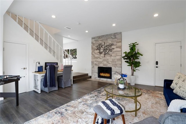 living area with stairs, wood finished floors, baseboards, recessed lighting, and a tiled fireplace