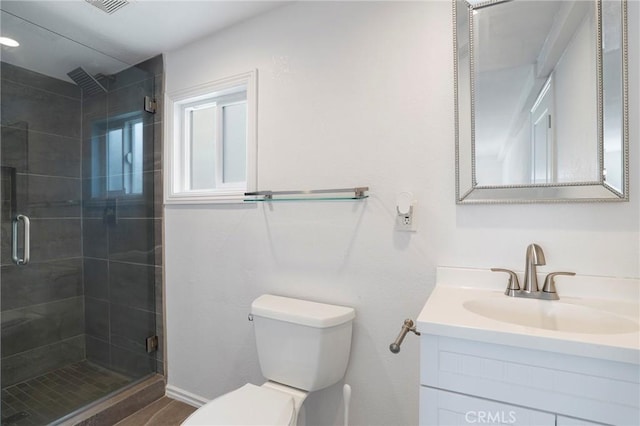 bathroom featuring vanity, baseboards, a shower stall, and toilet