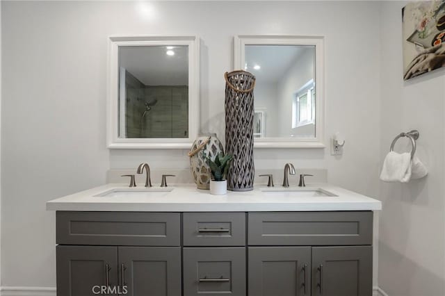 bathroom featuring double vanity, a sink, and a shower