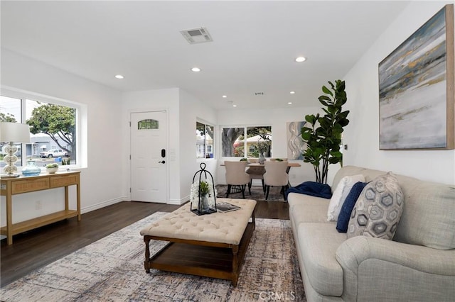 living area with baseboards, recessed lighting, wood finished floors, and visible vents