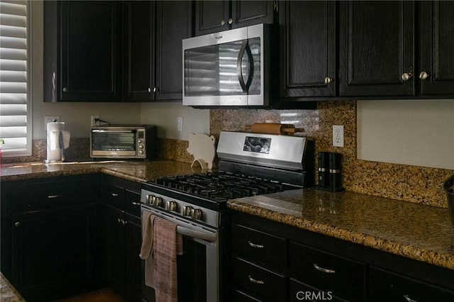 27069 Dawnview Ct, Corona, CA 92883 - kitchen with dark stone countertops, tasteful backsplash, dark cabinets, a toaster, and stainless steel appliances
