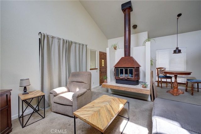 living room featuring high vaulted ceiling, carpet, baseboards, and a wood stove