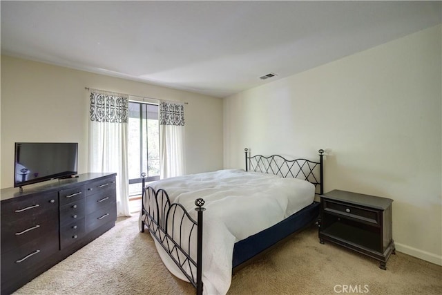 bedroom featuring baseboards, light carpet, and visible vents