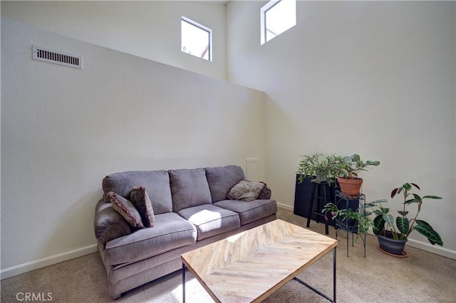 living area featuring baseboards, visible vents, and carpet