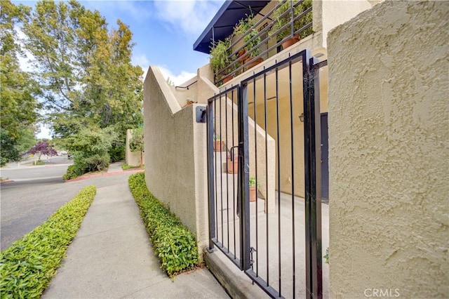 view of property exterior with a gate, stucco siding, and board and batten siding