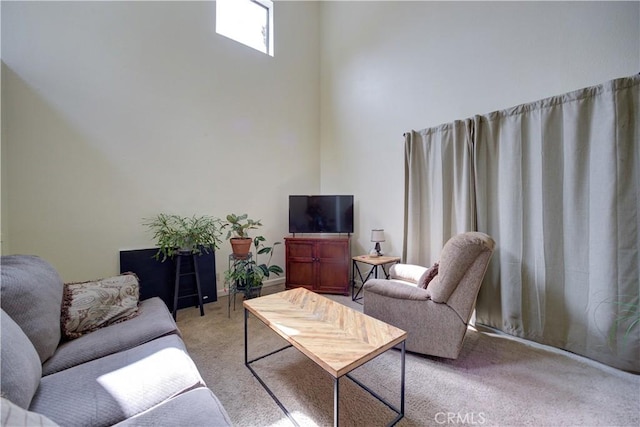 living area with a high ceiling and light carpet