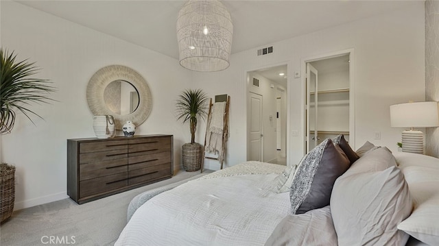 carpeted bedroom featuring visible vents, a spacious closet, a closet, and baseboards