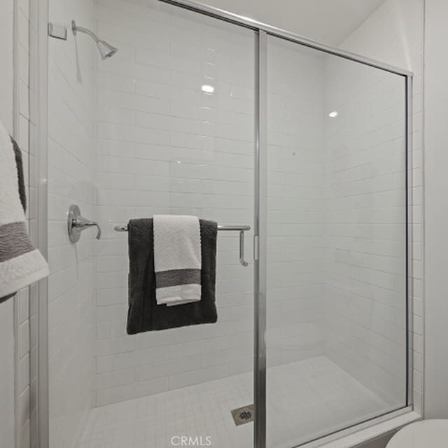 full bath featuring toilet and a stall shower
