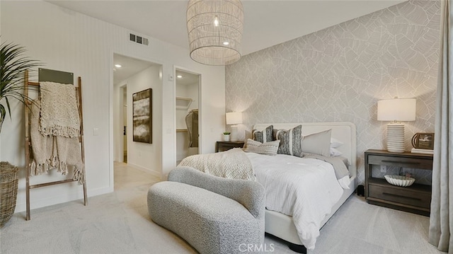carpeted bedroom featuring visible vents, a spacious closet, wallpapered walls, and baseboards