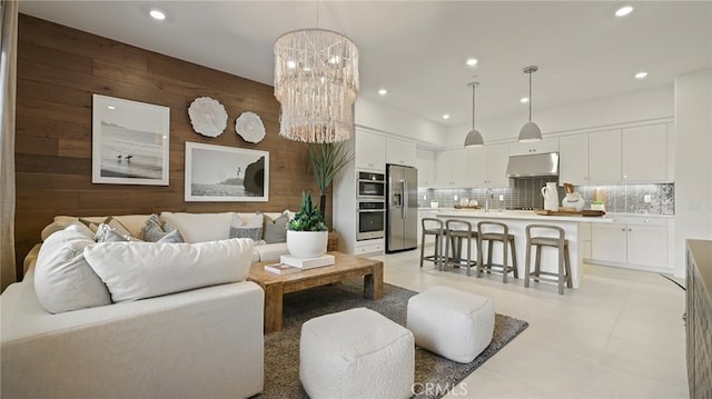 living area with wooden walls, recessed lighting, and a notable chandelier