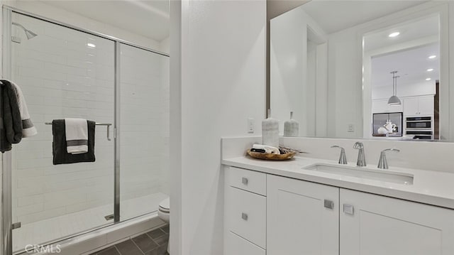full bath with toilet, a stall shower, recessed lighting, and vanity
