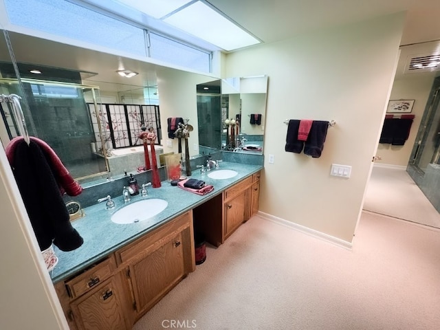 full bath with tiled shower, double vanity, and a sink
