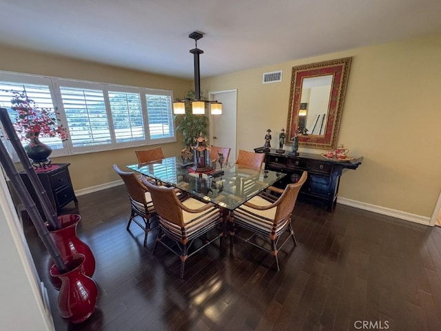 dining room featuring visible vents, wood finished floors, and baseboards
