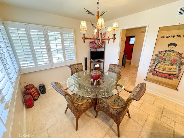 dining room featuring a chandelier, baseboards, and visible vents