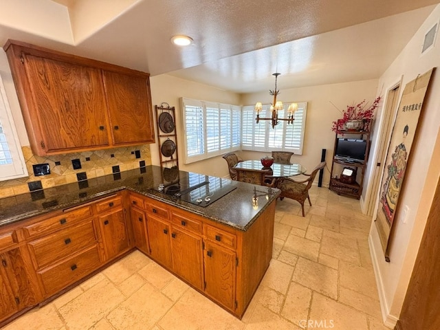 kitchen featuring stone tile floors, brown cabinetry, black electric cooktop, and decorative backsplash