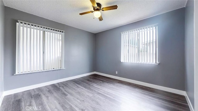 unfurnished room featuring a textured ceiling, a ceiling fan, wood finished floors, and baseboards