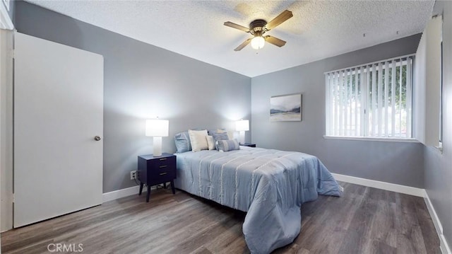 bedroom with baseboards, wood finished floors, a ceiling fan, and a textured ceiling