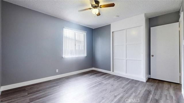 unfurnished bedroom featuring a closet, wood finished floors, and a textured ceiling