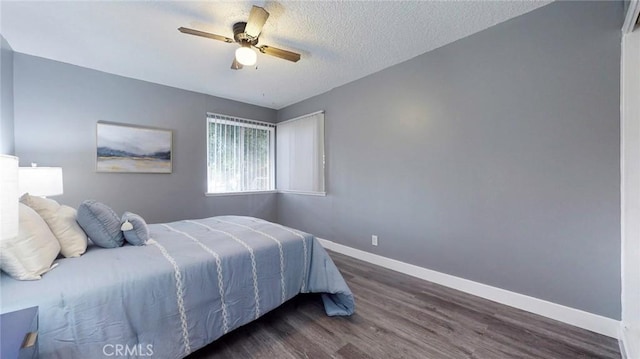 bedroom featuring dark wood-style flooring, a ceiling fan, a textured ceiling, and baseboards