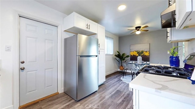 kitchen with black range with gas cooktop, ceiling fan, light wood-style flooring, and freestanding refrigerator
