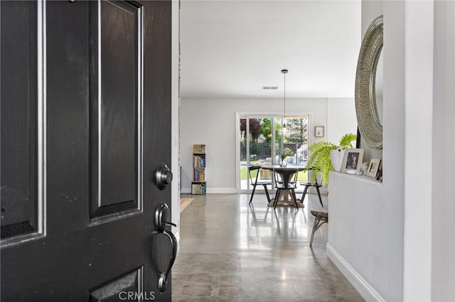 entryway with finished concrete flooring, visible vents, and baseboards