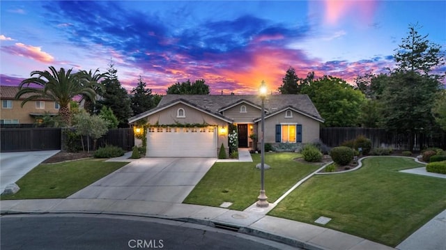 ranch-style home featuring stucco siding, fence, a front lawn, concrete driveway, and an attached garage