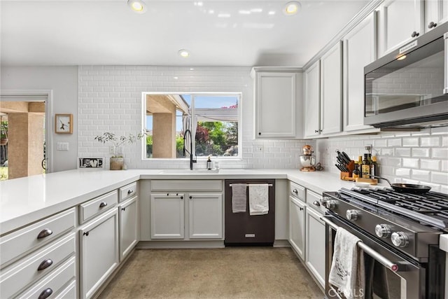 kitchen with range with gas stovetop, tasteful backsplash, light countertops, dishwashing machine, and recessed lighting