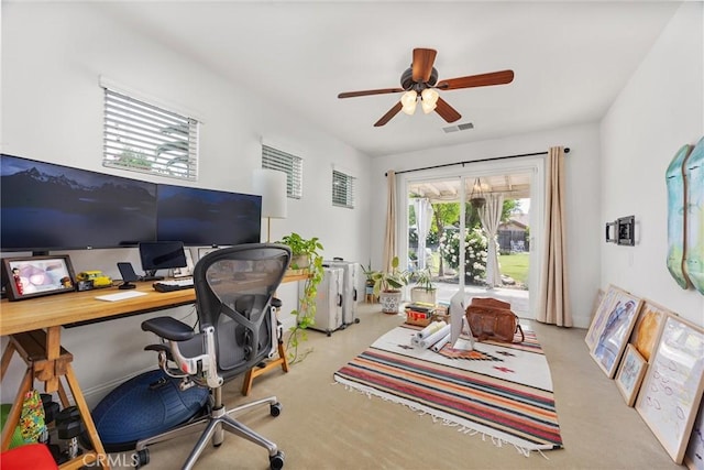carpeted home office featuring a ceiling fan and visible vents