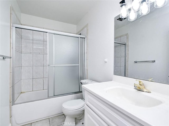 bathroom with toilet, tile patterned flooring, shower / bath combination with glass door, and vanity