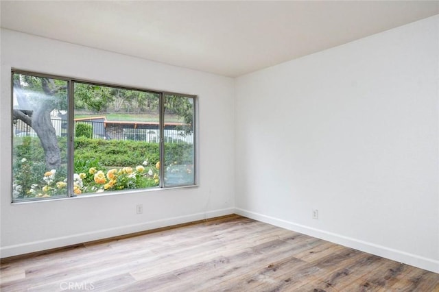 empty room featuring wood finished floors and baseboards