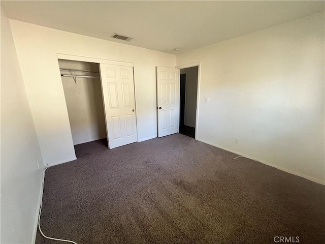 6320 Mesquite Ave Unit 29, Palms, CA 92277 - unfurnished bedroom with dark carpet, visible vents, a closet, and baseboards