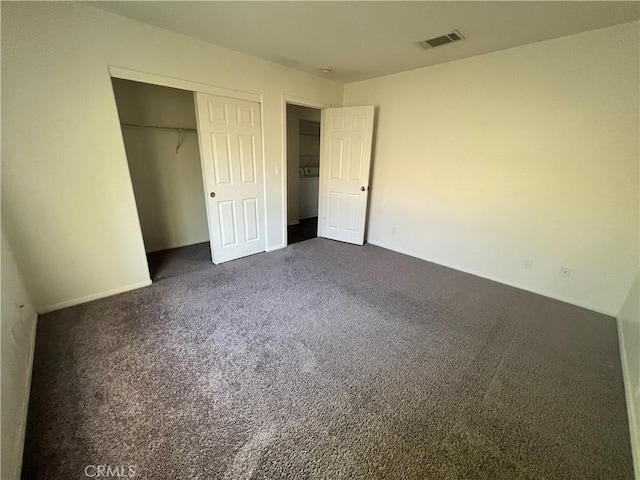 6320 Mesquite Ave Unit 29, Palms, CA 92277 - unfurnished bedroom featuring baseboards, visible vents, dark carpet, and a closet