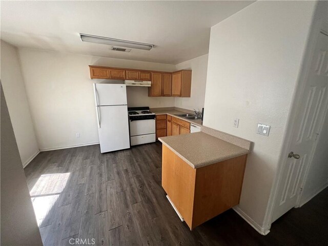 6320 Mesquite Ave Unit 29, Palms, CA 92277 - kitchen with a sink, baseboards, under cabinet range hood, dark wood-style flooring, and white appliances