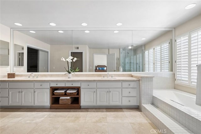 full bathroom featuring recessed lighting, double vanity, and a sink