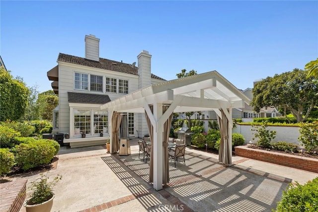 rear view of property with a patio, a chimney, outdoor dining area, and a pergola