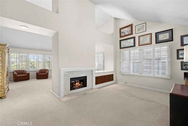 unfurnished living room featuring carpet flooring, baseboards, high vaulted ceiling, and a fireplace