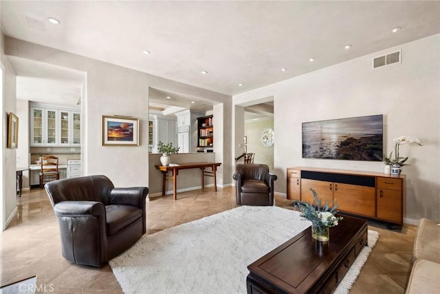 living room featuring baseboards, visible vents, light tile patterned flooring, and recessed lighting