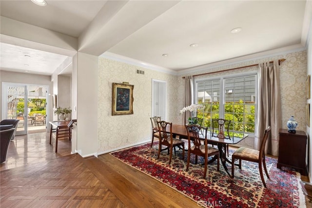dining area with baseboards, wallpapered walls, visible vents, and crown molding