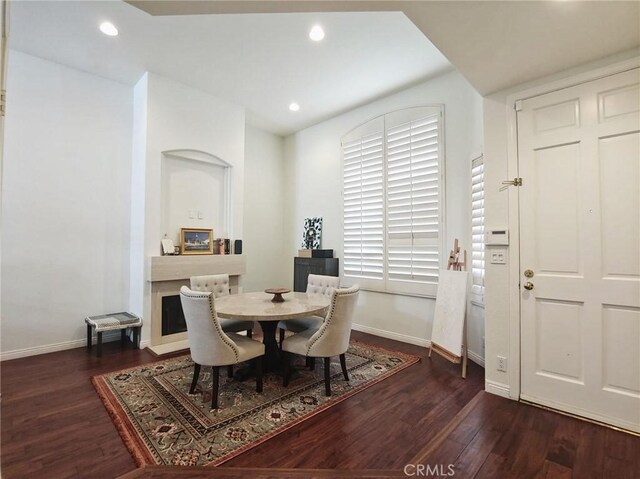 dining area featuring baseboards, wood finished floors, and recessed lighting