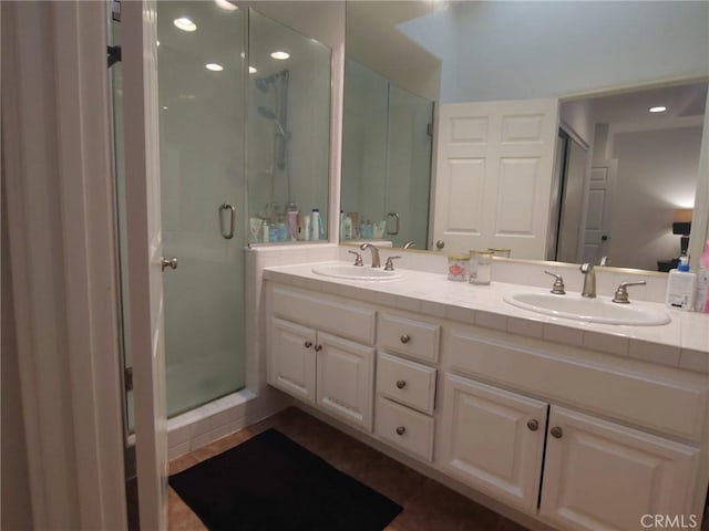 full bath with a shower stall, double vanity, and recessed lighting