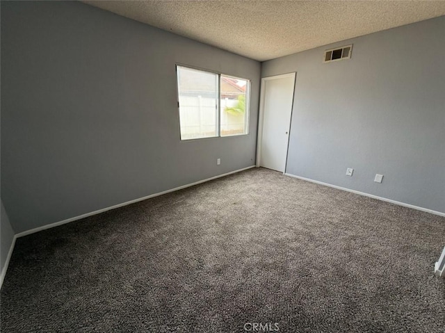 unfurnished room featuring visible vents, a textured ceiling, carpet, and baseboards