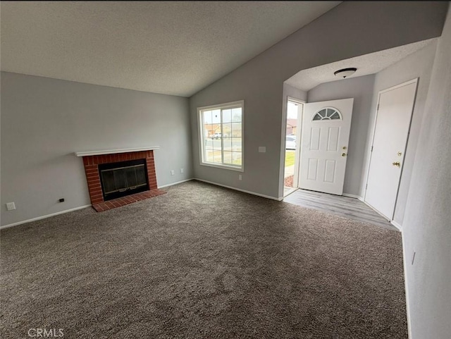 unfurnished living room with carpet floors, baseboards, vaulted ceiling, and a fireplace