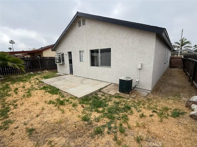 back of house with a patio, a fenced backyard, stucco siding, and central AC unit