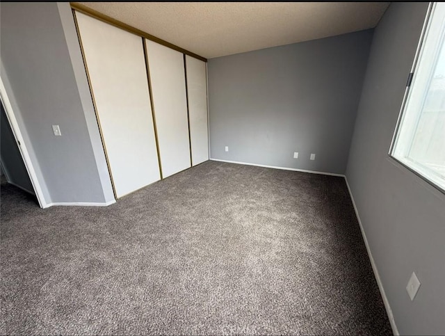 unfurnished bedroom with a closet, carpet flooring, and baseboards